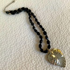 Black beaded necklace with silver leaf
